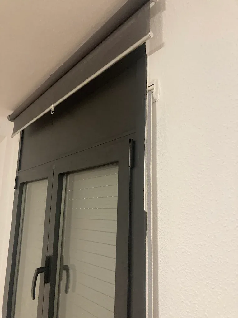 Instalación de persiana de aluminio en puerta balconera en Barcelona — vista lateral del cajón