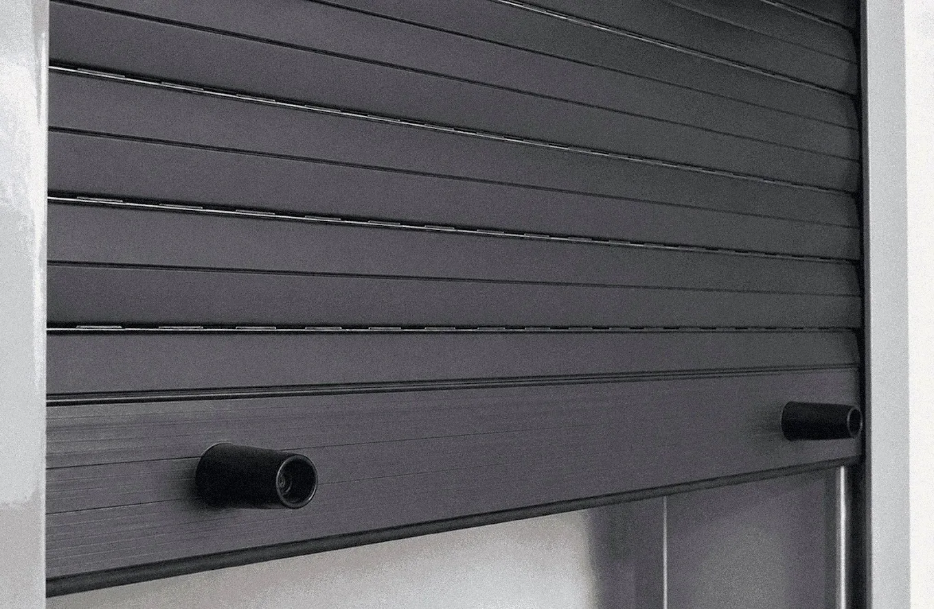 Detalle de las lamas de una persiana de aluminio gris oscuro preparada para motorizar