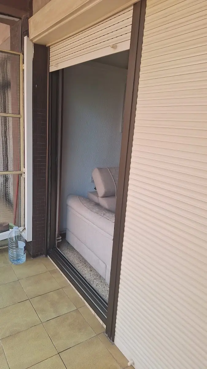 Balconera de un salón con persiana beige y cajón instalados