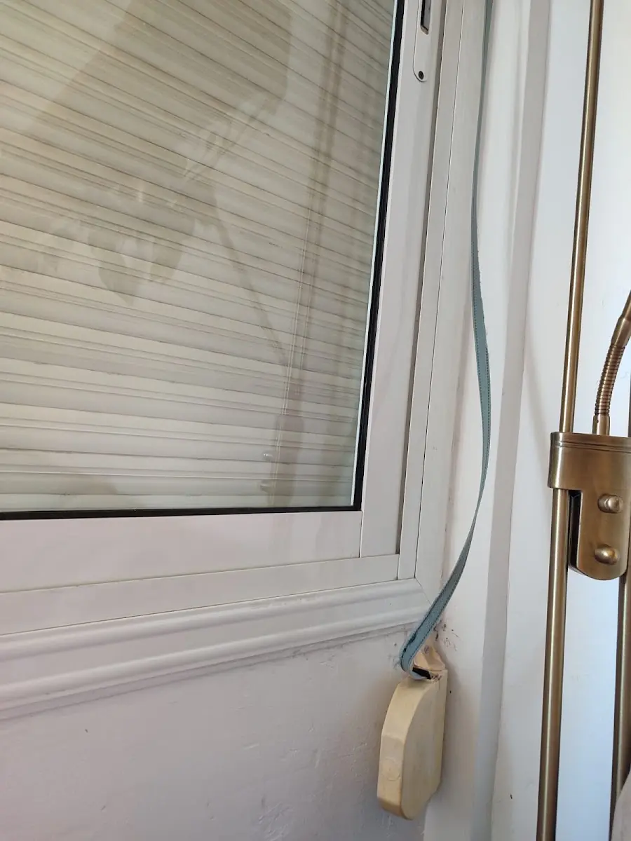 Recogedor de cinta de persiana junto a la ventana de una vivienda