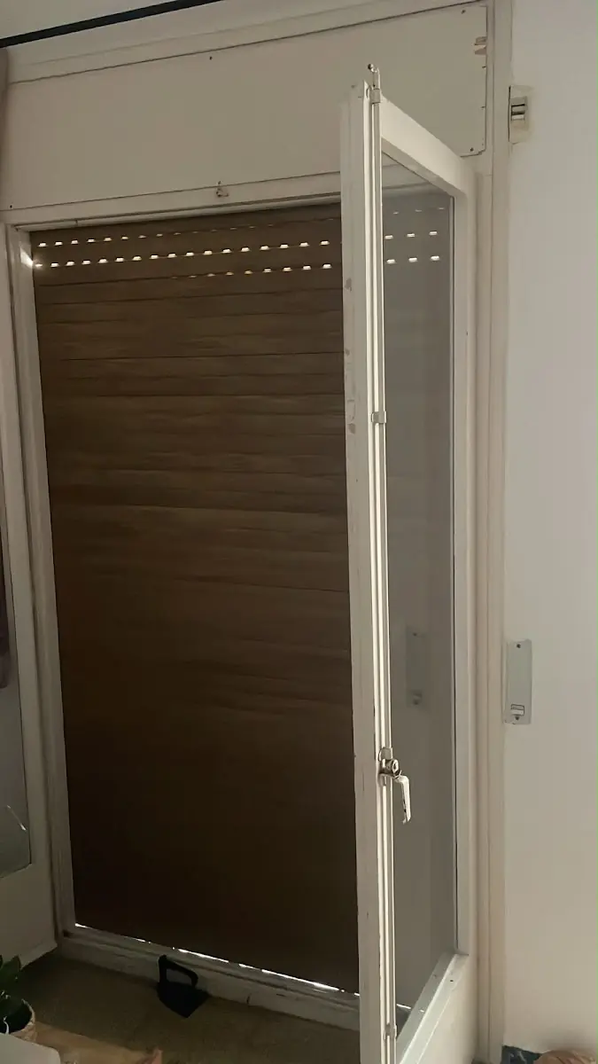 Puerta balconera con la persiana marrón bajada tras la instalación