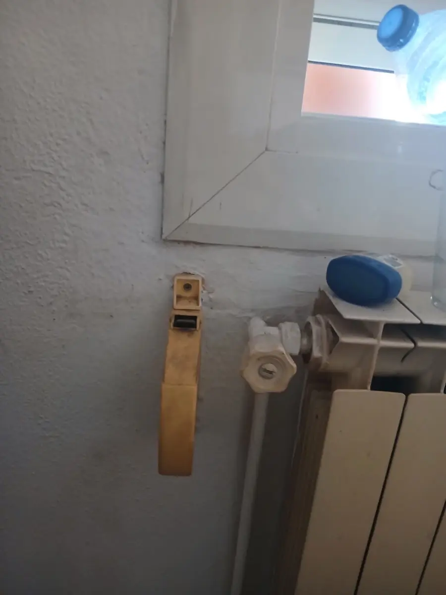 Recogedor de cinta de persiana junto a un radiador